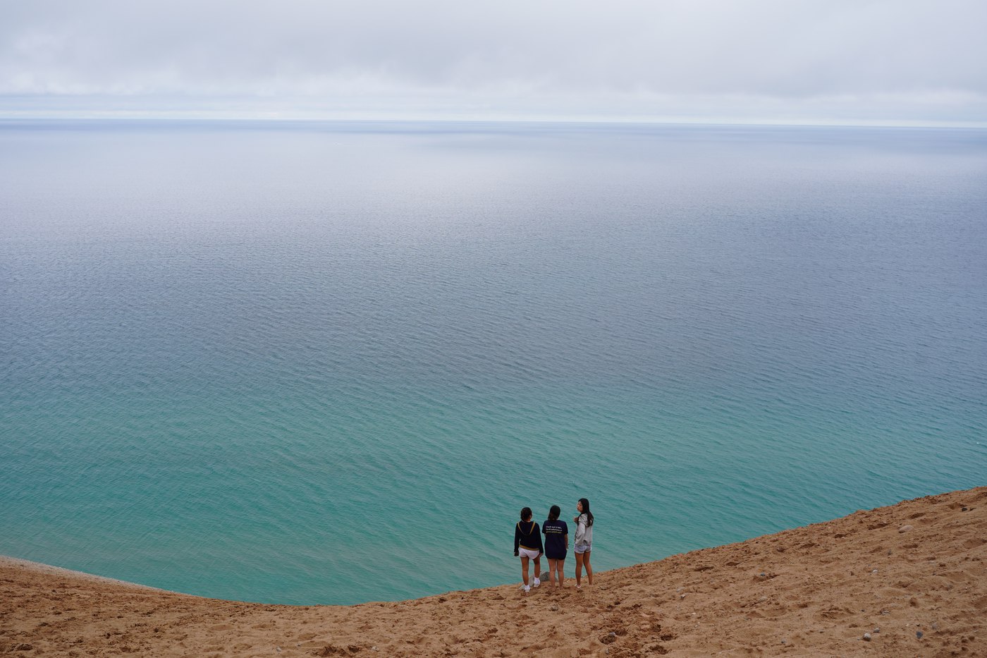 Three people on a dune above Lake Michigan
